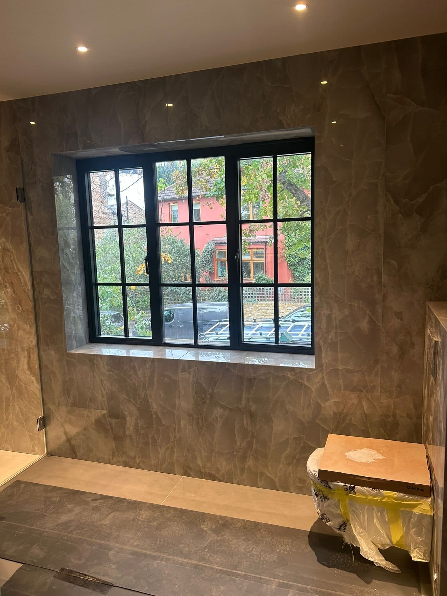 Stone-lined shower room with steel-framed window